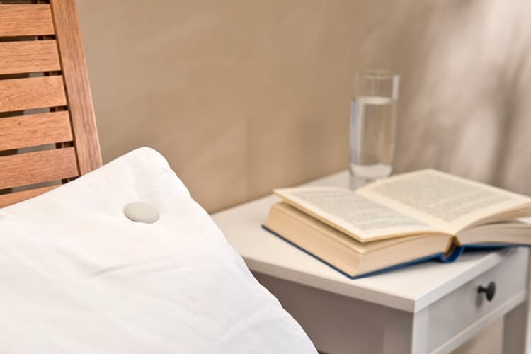 Der Sleeptracker von newgen medicals wird ins Kopfkissen geclipt und zeichnet Schlafdaten auf