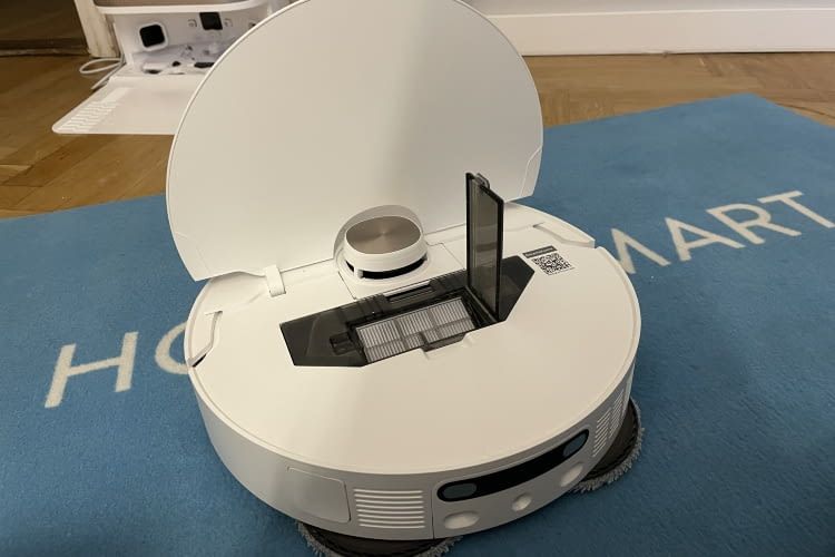 Der Staubbehälter des Roboters mit HEPA-Filter ist unter der Abdeckung zu finden