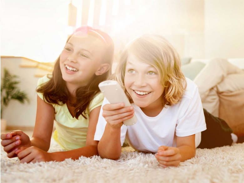 Bambini in salotto con telecomando