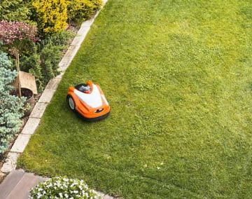 Ein Mähroboter pflegt den Rasen bei jedem Wetter