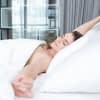 Frau wacht im Bett auf