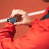 Sportler guckt auf Smartwatch am Handgelenk