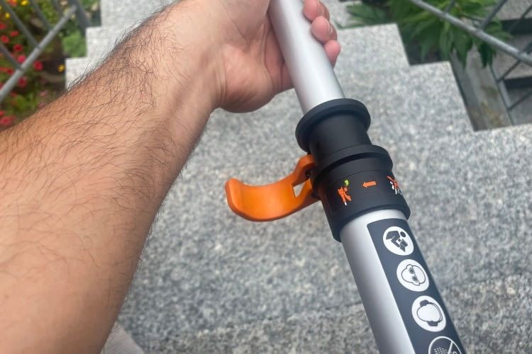 Mit dem orangenen Hebel lässt sich die Länge des Rasentrimmers mühelos einstellen Mit dem orangenen Hebel lässt sich die Länge des Rasentrimmers mühelos einstellen