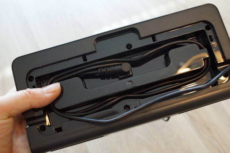 Einmal aufgewickelt und unter der Gehäuseabdeckung versteckt, ist das Kabel später nicht mehr sichtbar Einmal aufgewickelt und unter der Gehäuseabdeckung versteckt, ist das Kabel später nicht mehr sichtbar