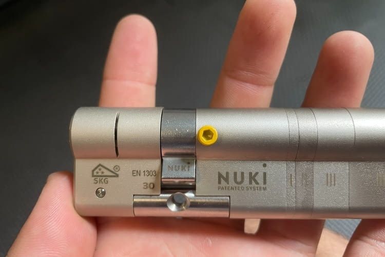 Bevor der Zylinder in die Tür kann, muss die kleine grüne Schraube entfernt werden Bevor der Zylinder in die Tür kann, muss die kleine grüne Schraube entfernt werden