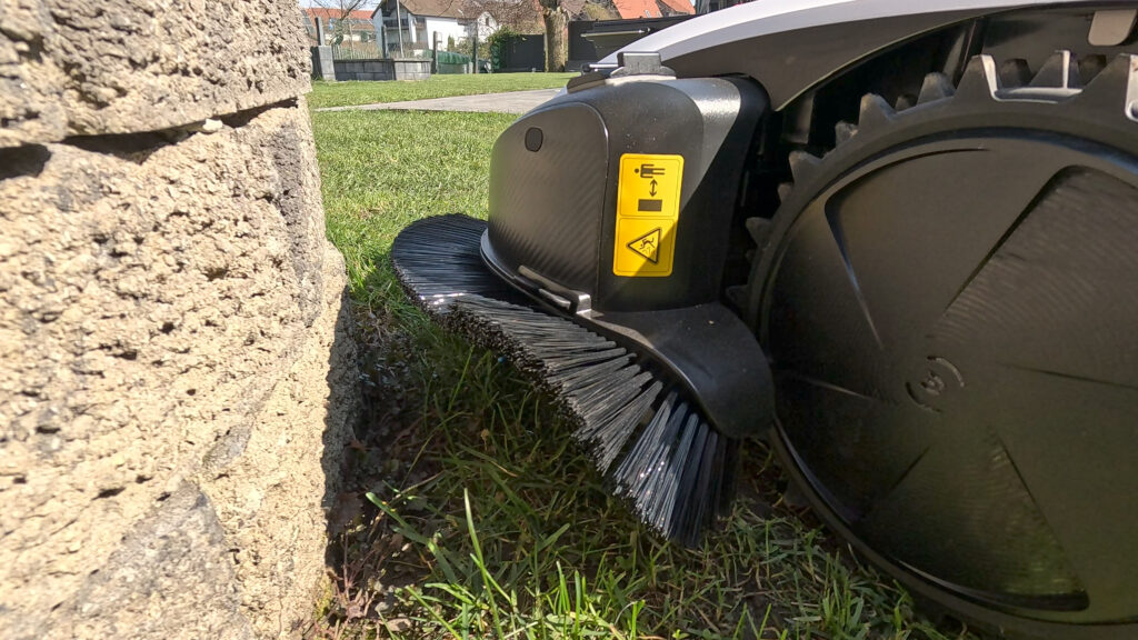 Der TruEdge Trimmer funktioniert wie ein Rasentrimmer und ist seitlich am Mähroboter angebracht