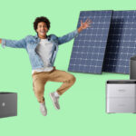 Mann macht Luftsprünge vor Solarmodulen und Stromspeichern