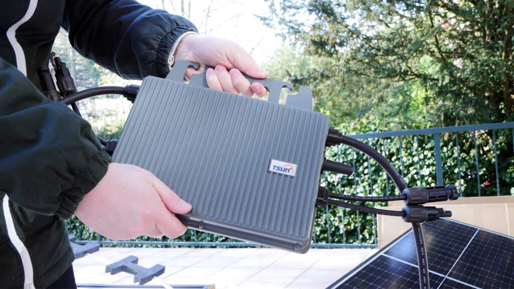 welche-wechselrichter-sind-normenkonform Hand hält Wechselrichter in die Kamera