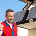 Fröhlicher Mann vor Solarmodulen