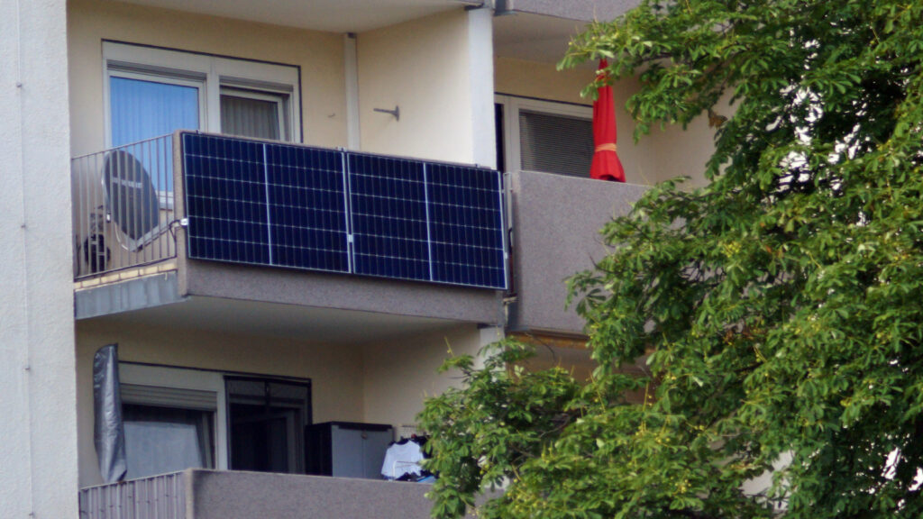 was-gilt-bei-balkonkraftwerken-fuer-mieter-rechtlich Zwei Solarmodule am Betonbalkon eines Hochhauses
