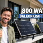 Man steht vor mehreren Balkonen mit Mini-Solaranlagen daran und zeigt einen Daumen nach oben