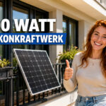 Junge Frau steht vor einem Solarmodul am Balkon und zeigt zwei Daumen nach oben