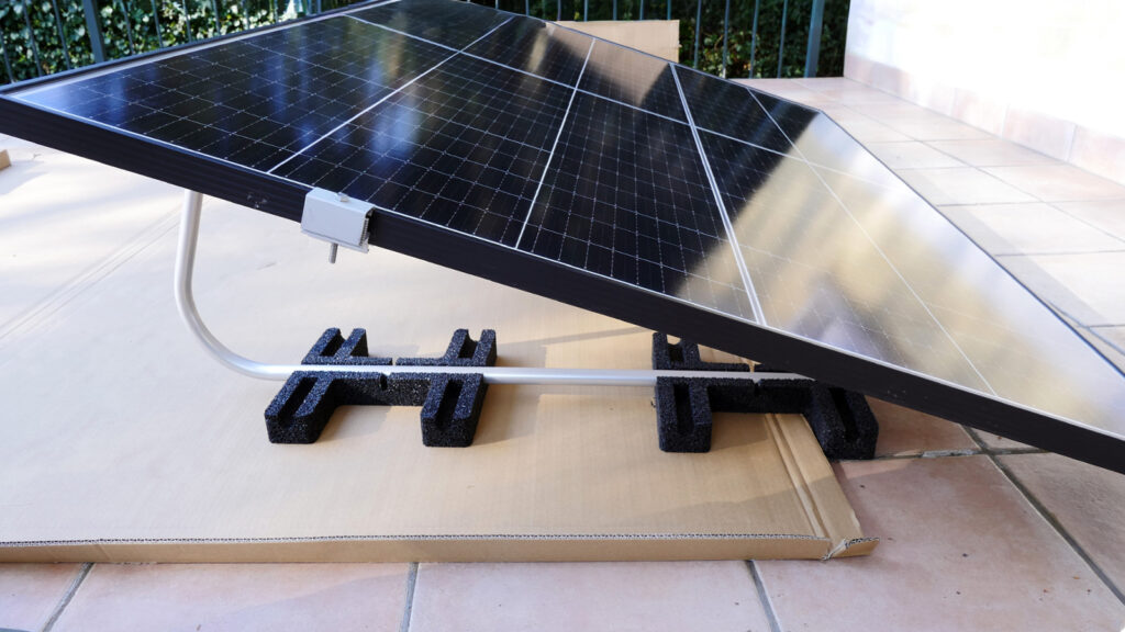 wie-baue-ich-solarmodul-halterungen-richtig-auf Bei dieser Bodenhalterung werden zur Beschwerung Steinplatten auf die schwarzen Gummifüße gelegt