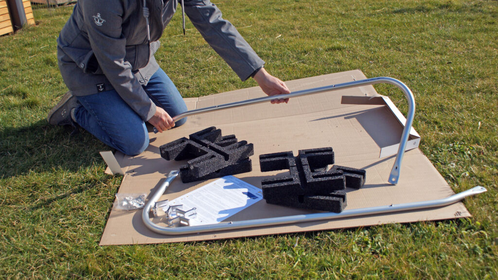 wie-stabil-muessen-solarmodul-halterungen-sein Hand hebt Balkonkraftwerk Halterung aus einer Verpackung