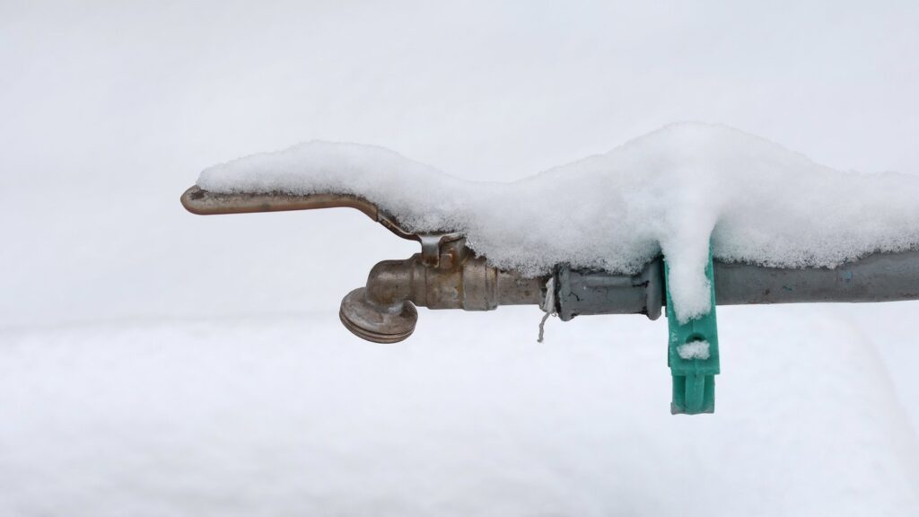 Verschneiter Außenwasserhahn: Leitungen im Garten sollten vor dem Winter abgesperrt und entleert werden.