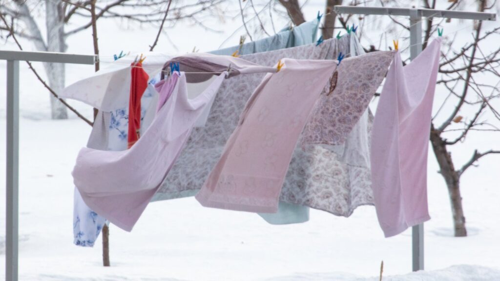 Wäsche an der Leine im Schnee: Laut Verbraucherzentrale Niedersachsen kannst du Wäsche auch bei Frost draußen aufhängen.