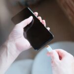 Eine Hand steckt ein USB-C-Ladekabel in ein Smartphone.