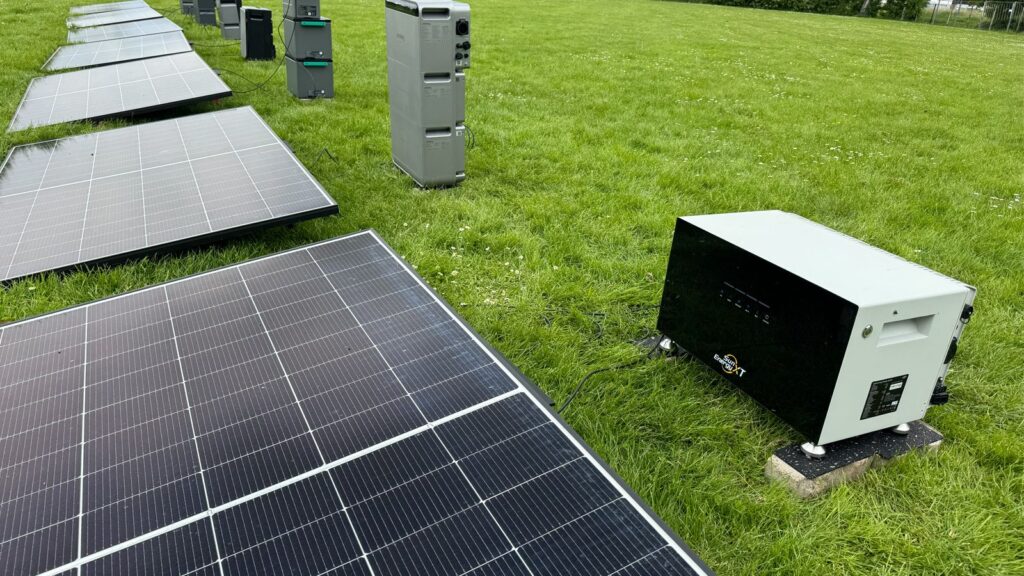SunEnergyXT-Speicher im Feldtest neben Solarmodulen auf einer Wiese